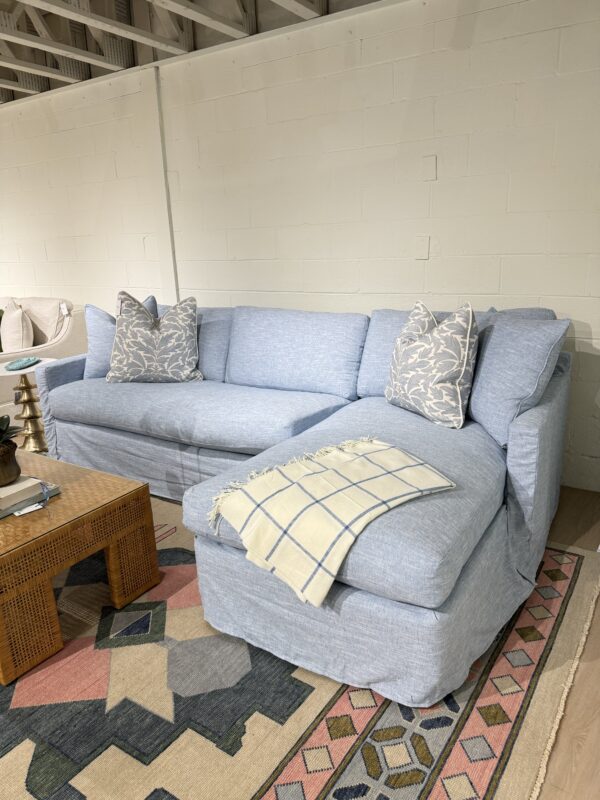 Blue slipcovered sofa with a chase lounge covered in performance fabric with down blend cushion fill