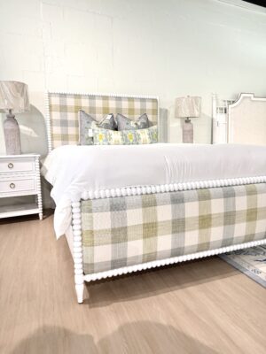 Queen spool bed in a white wooden finish with green blue and neutral gingham upholstered fabric, headboard, and footboard