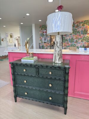 Faux bamboo green chest with soft clothes, drawers, and gold hardware