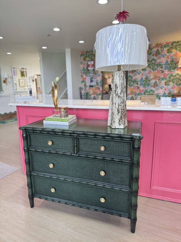 Faux bamboo green chest with soft clothes, drawers, and gold hardware