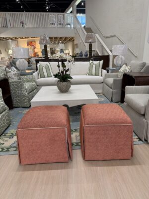 Set of (2) Skirted Rolling Storage Ottomans | orange red fabric with neutral welt and underskirt